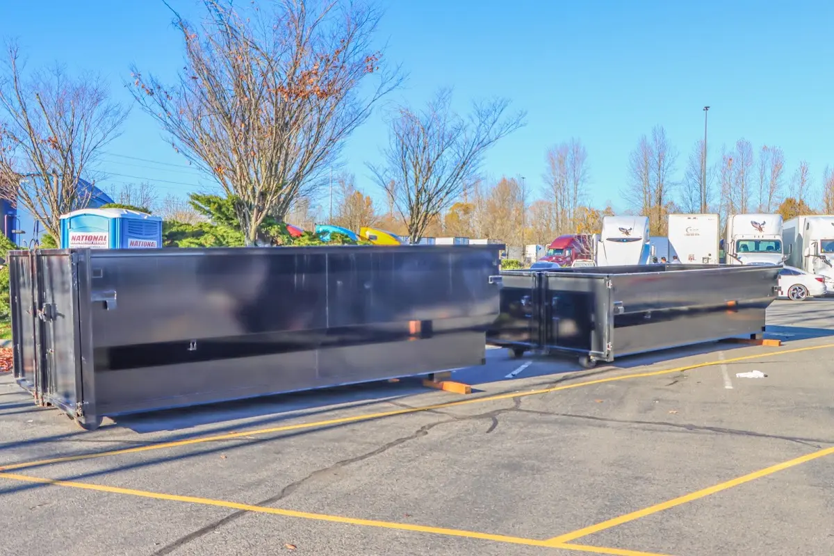 Professional dumpster rental service with roll-off container on residential driveway in Woonsocket